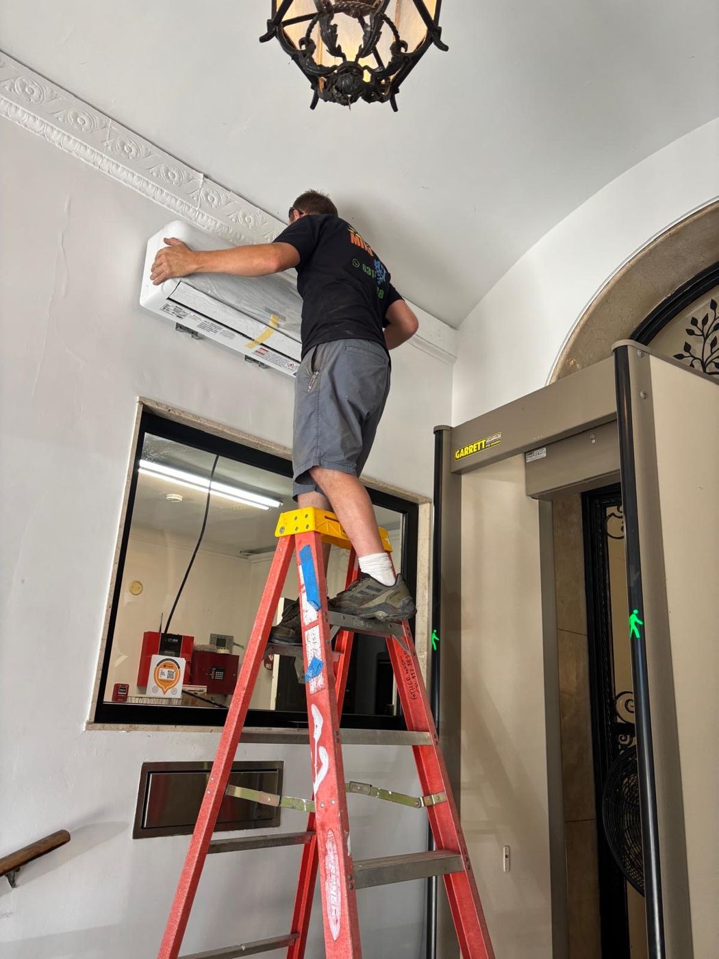 Technician mounting a ductless mini-split indoor unit at the Embassy of France
